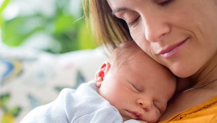 Baby liegt auf Bauch der Mutter